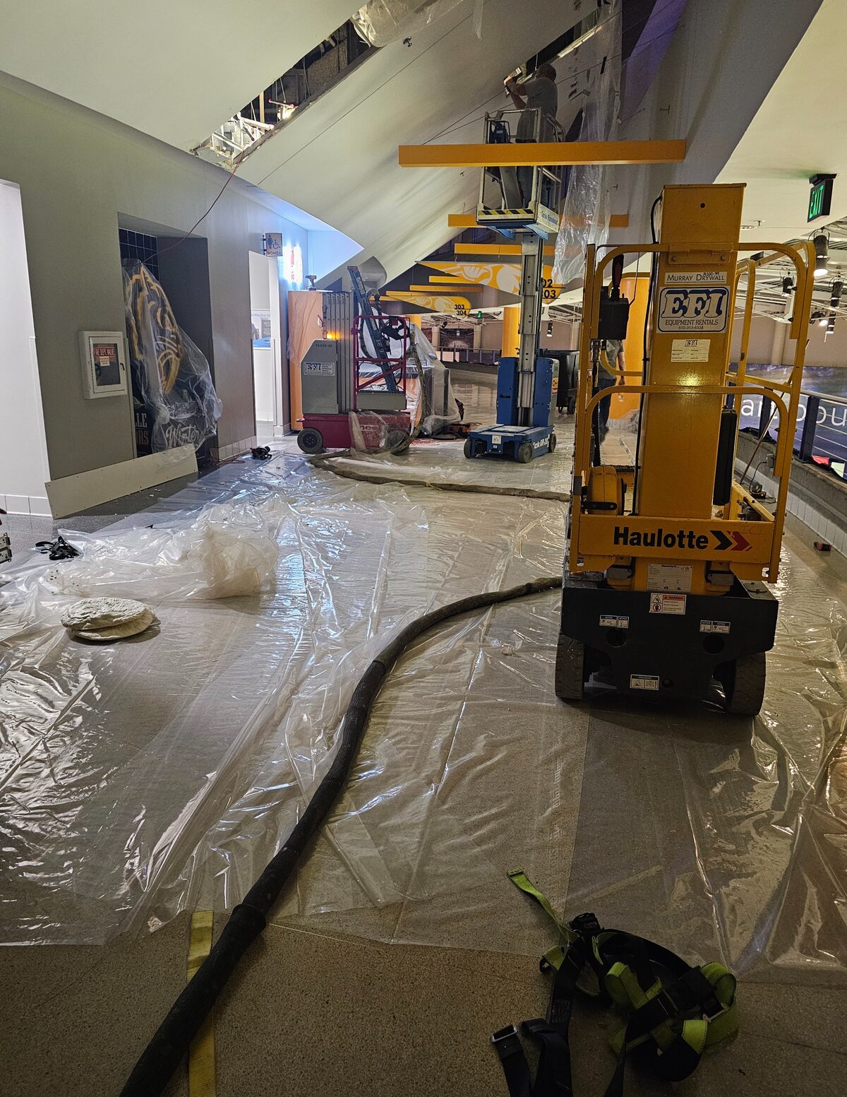 Volunteer FoamPros spray foam equipment and lift set up on a protected concourse floor during the Bridgestone Arena project in Nashville