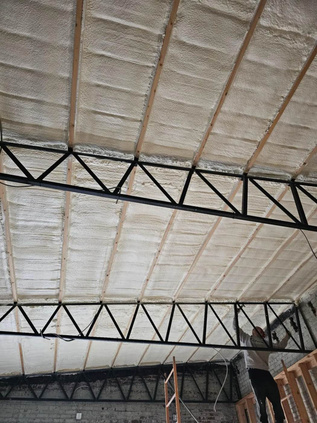 Spray foam insulation on the trusses of a steel frame building