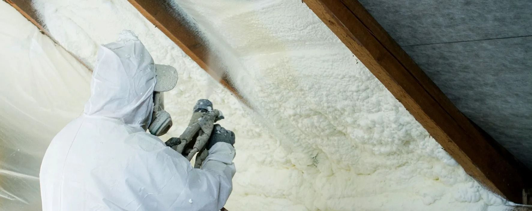 A Volunteer FoamPros technician spraying closed cell foam along the roofline of a Middle Tennessee attic