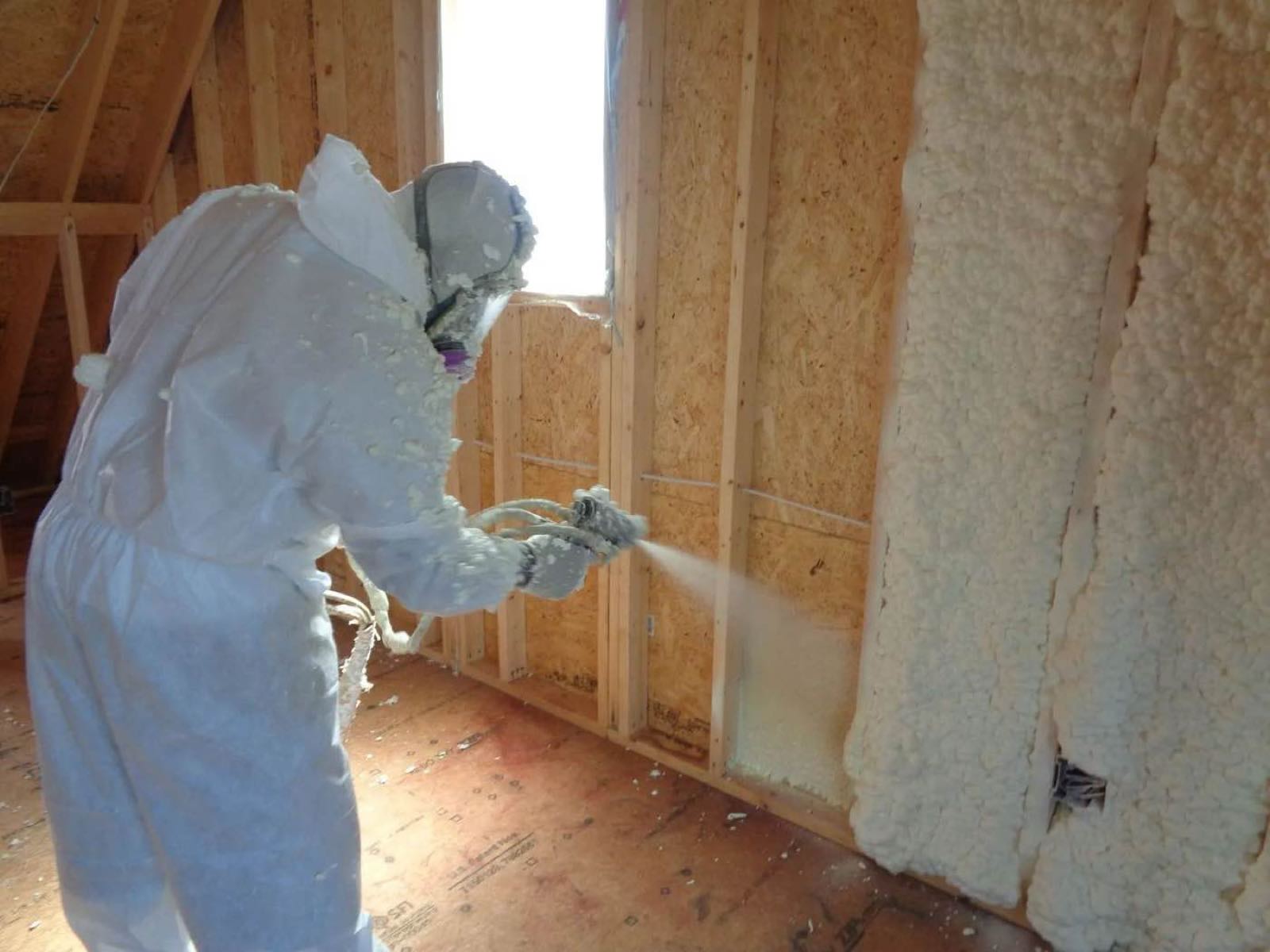 A Volunteer FoamPros technician spraying open-cell foam into the wall framing of a Middle Tennessee house